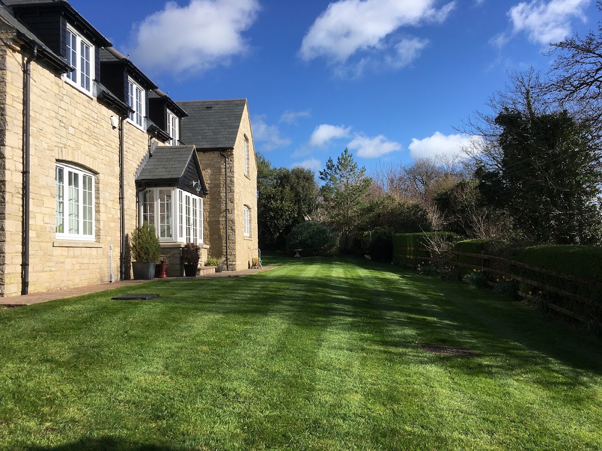 A freshly striped lawn beside a Dorset stone cottage