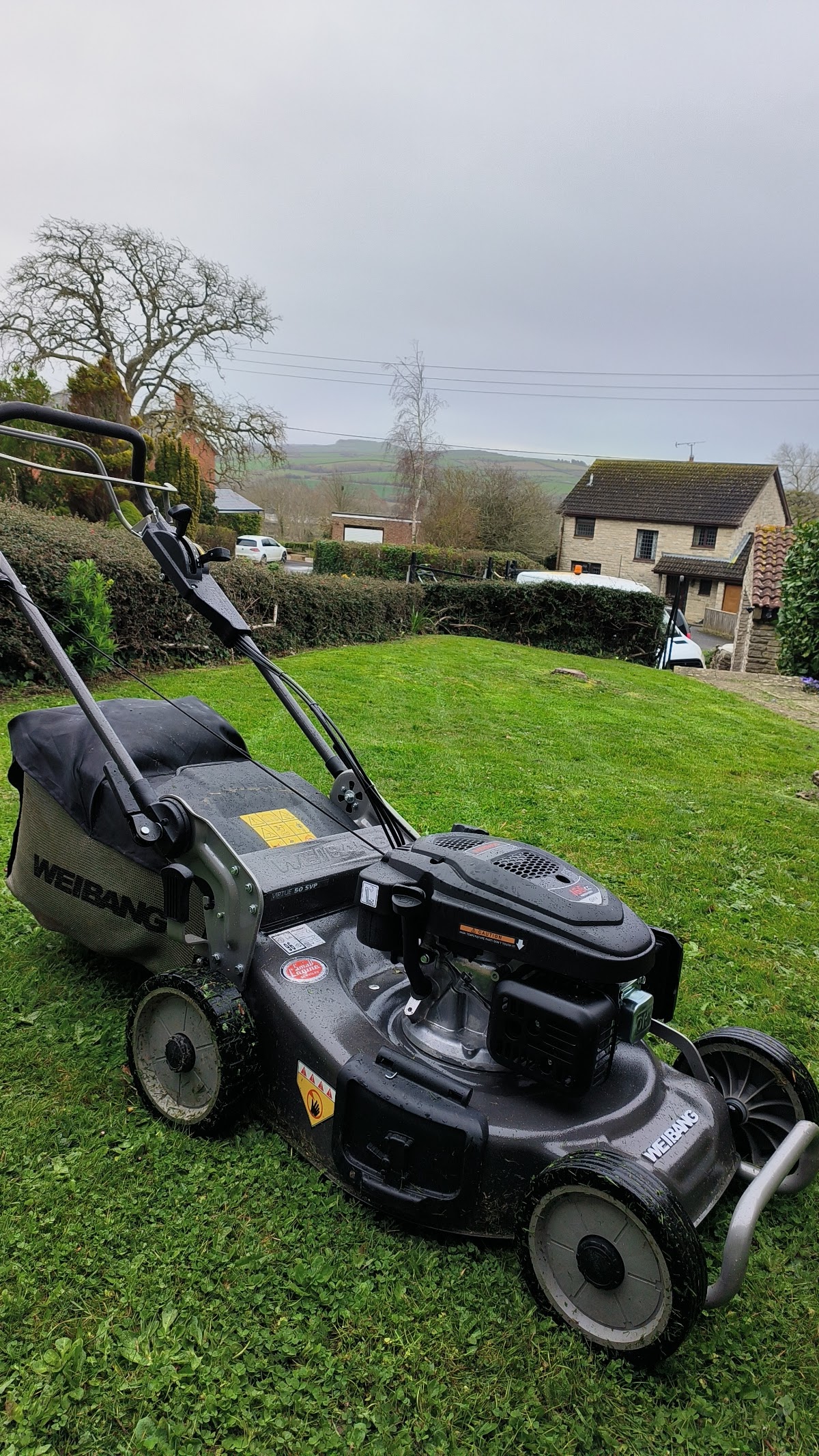 Lawnmower in a garden with rolling Dorset hills in the background